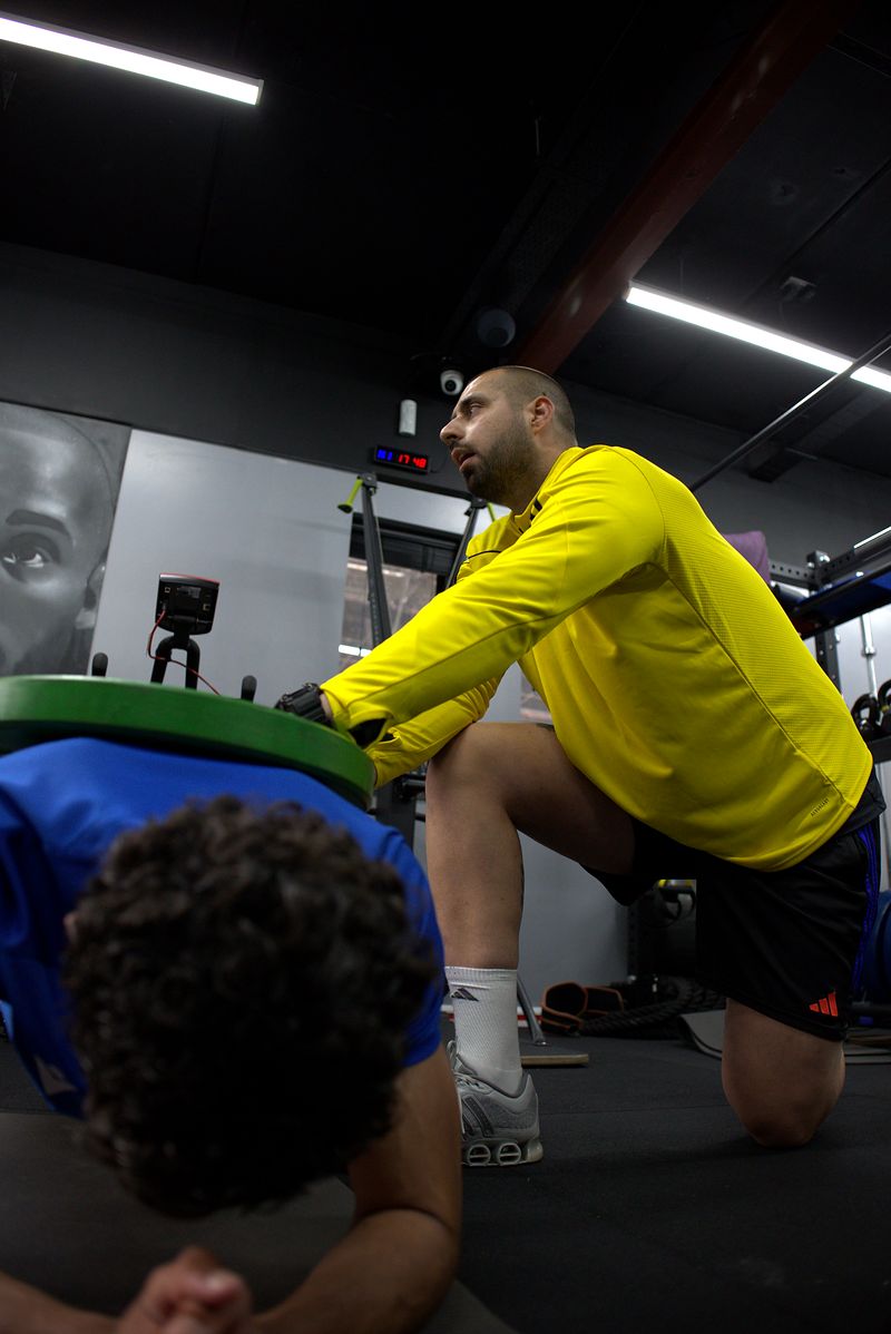 Dion Tsolakis loading a plate during Hassan Ayub&rsquo;s session